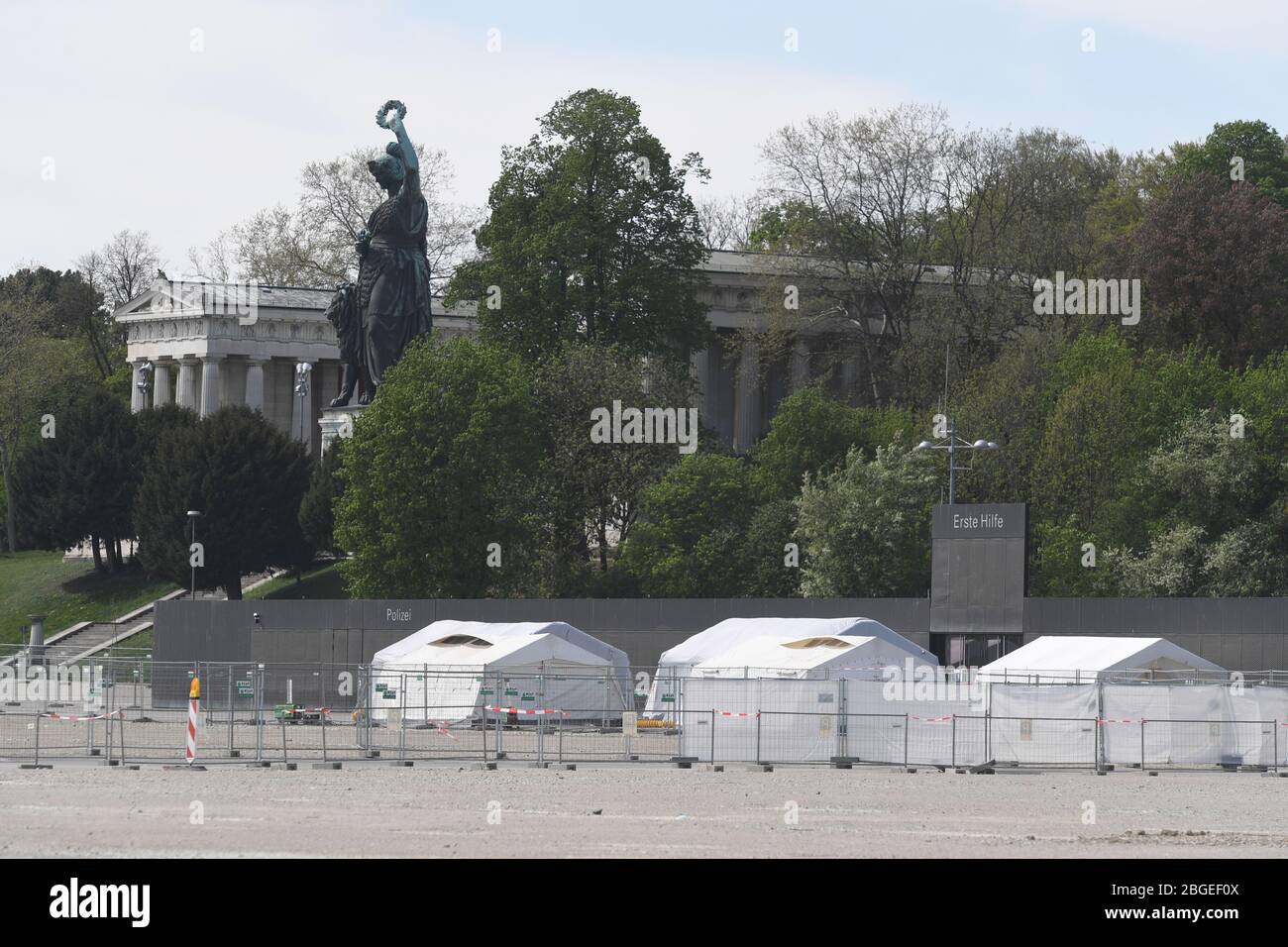 Monaco, Germania. 21 Apr 2020. La statua della Baviera è collocata sopra le tende della stazione di prova drive-in sul Theresienwiese per persone con sospetto Covid-19. La più grande festa pubblica del mondo non si svolgerà nel 2020 a causa della pandemia di Corona. Ciò è stato annunciato oggi dal Presidente del Ministro bavarese e dal Signore Sindaco di Monaco. Credit: Felix Hörhager/dpa/Alamy Live News Foto Stock