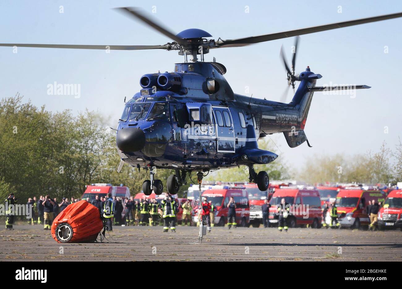 21 aprile 2020, Renania settentrionale-Vestfalia, Brüggen: Un elicottero decollo da Brüggen con un serbatoio esterno collegato per l'acqua antincendio. Un incendio grave in un parco nazionale olandese al confine con la Renania settentrionale-Vestfalia sta causando problemi ai servizi di emergenza. Un portavoce delle autorità di sicurezza della provincia di Limburgo ha detto martedì alla radio olandese che il lavoro di estinzione è reso più difficile da forti venti. Foto: David Young/dpa Credit: dpa Picture Alliance/Alamy Live News Foto Stock