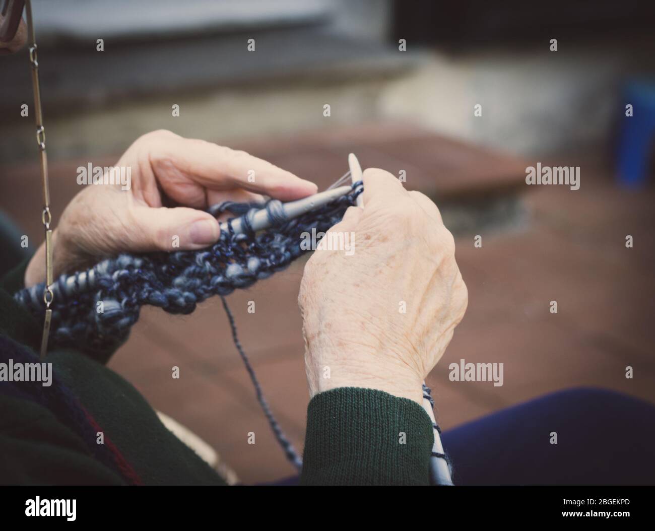 primo piano su vecchia signora mani a maglia in una terrazza Foto Stock
