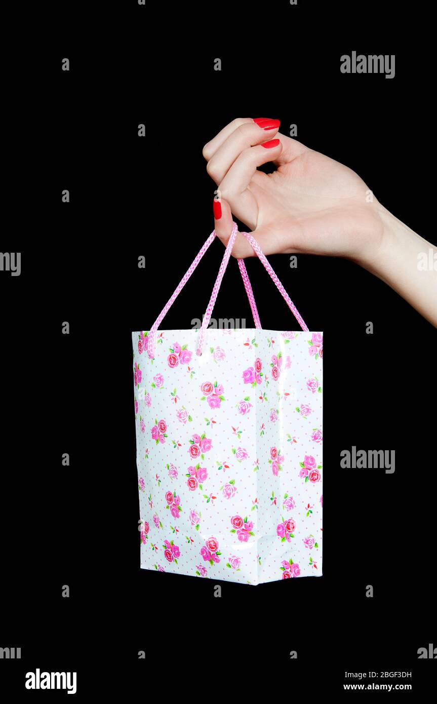 Primo piano della mano femminile con una borsa da shopping sul suo piccolo dito Foto Stock