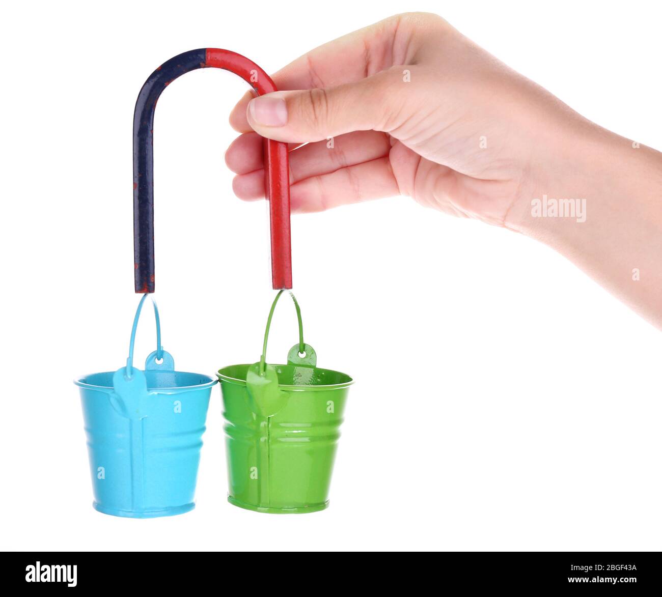 Magnete in mano che tiene piccoli secchi in ferro isolati su bianco Foto Stock