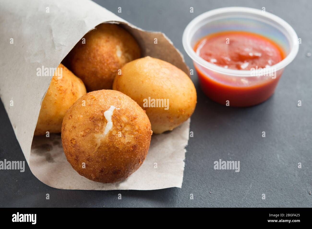 Risotto fritto Arancini ripieno di formaggio, servito con salsa di pomodoro Foto Stock