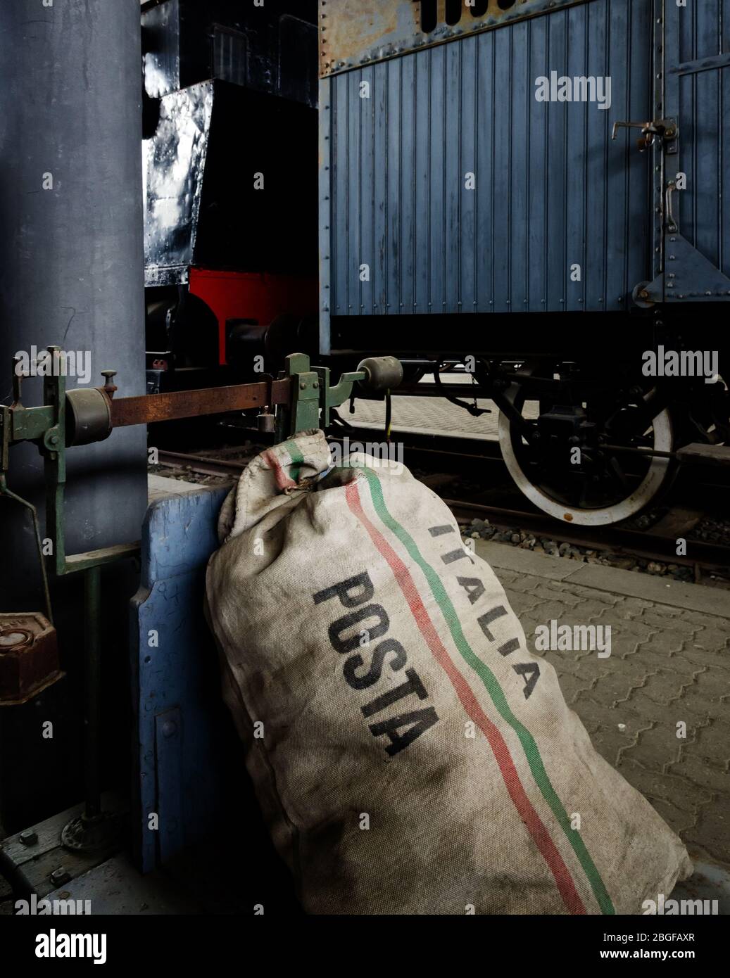 Bilancia e borsa postale di servizio postale italiano sulla piattaforma di una stazione ferroviaria Foto Stock