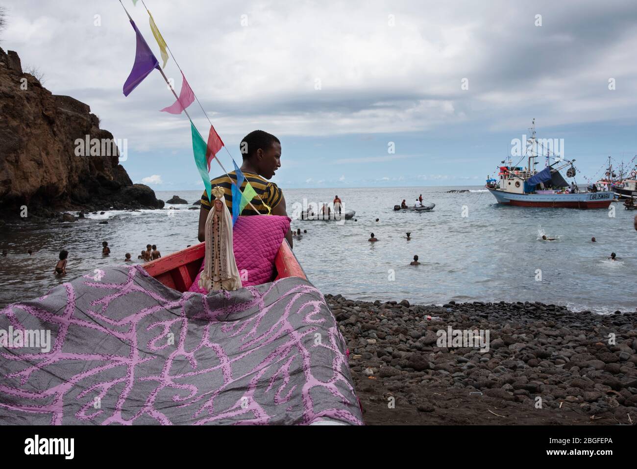 Uomo accanto alla barca al festival dei pescatori, Cidade Velha, Capo Verde. Foto Stock