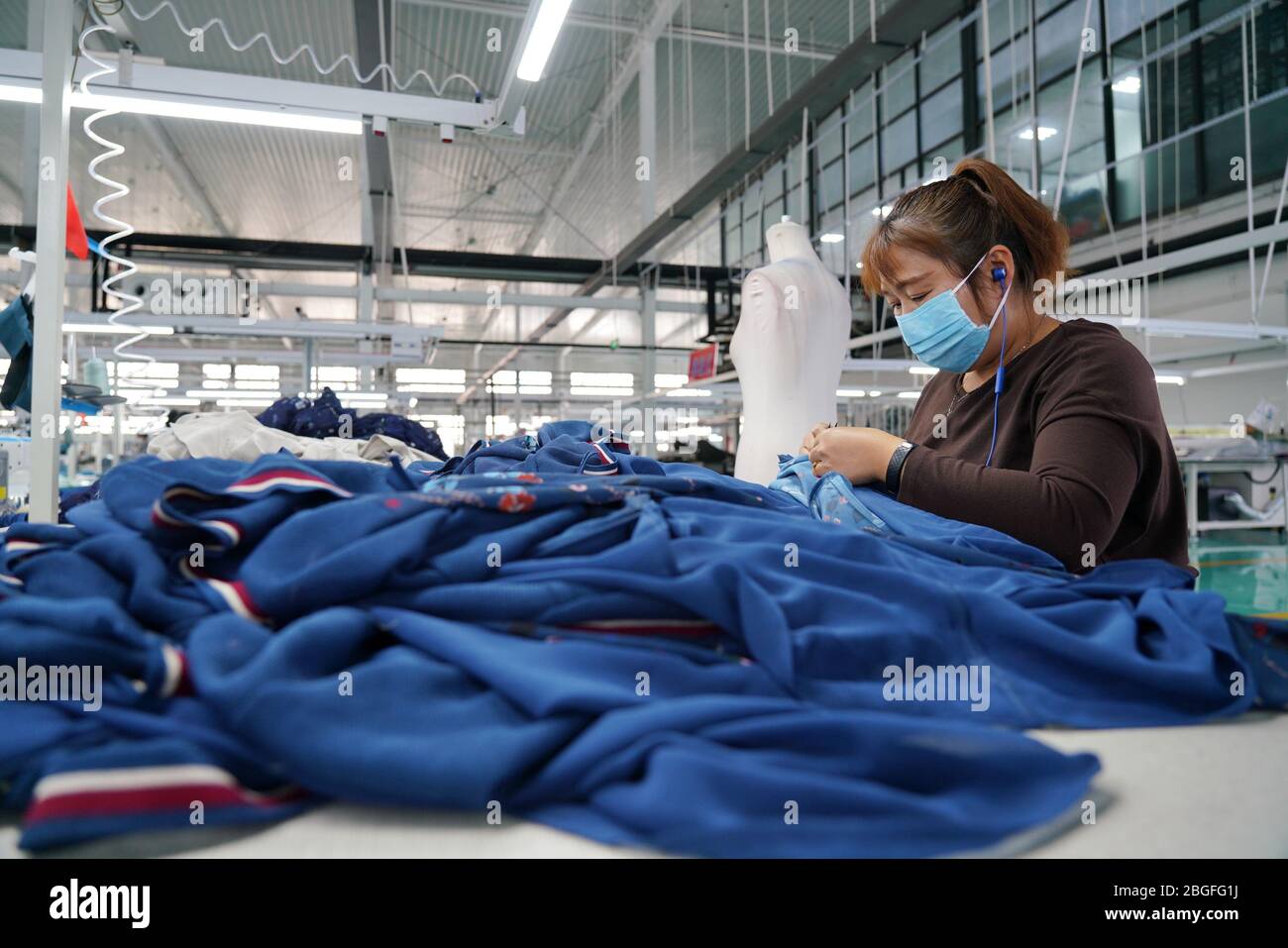 Xingtai, provincia cinese di Hebei. 21 Apr 2020. Una donna lavora in una fabbrica di abbigliamento a Nangong City, nella provincia di Hebei, nel nord della Cina, il 21 aprile 2020. Le imprese di Nangong hanno intensificato la produzione da aprile per digerire il ritardo degli ordini dovuto all'epidemia di COVID-19. Credit: MU Yu/Xinhua/Alamy Live News Foto Stock