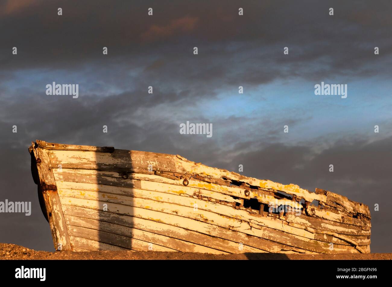 un relitto di una barca al tramonto con spettacolari nuvole sullo sfondo Foto Stock