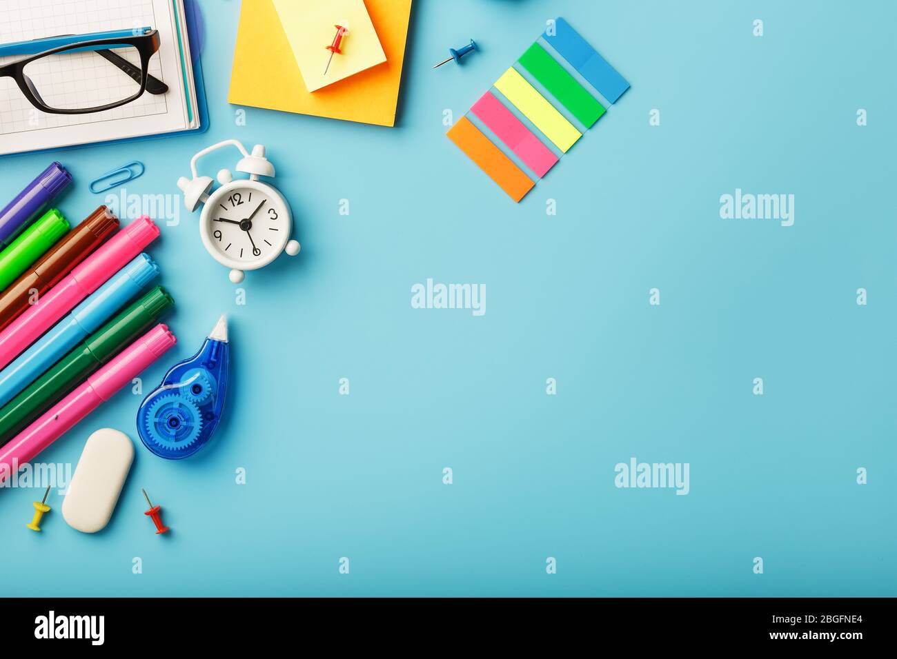 I materiali per ufficio si trovano su uno sfondo blu. Per studiare a scuola. Colore arcobaleno. Spazio libero Foto Stock