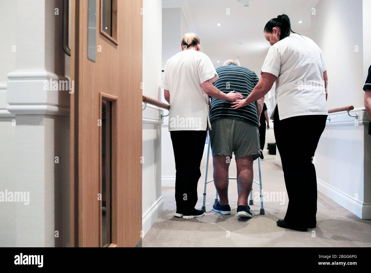 Il personale assiste un uomo utilizzando una cornice zimmer in una casa di cura residenziale a Redcar, Regno Unito. 2/2/2018. Fotografia: Stuart Bolton. Foto Stock