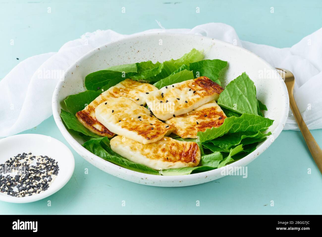 dieta keto-ketogena haloumi con lattuga su sfondo pastello primo piano, cibo sano Foto Stock