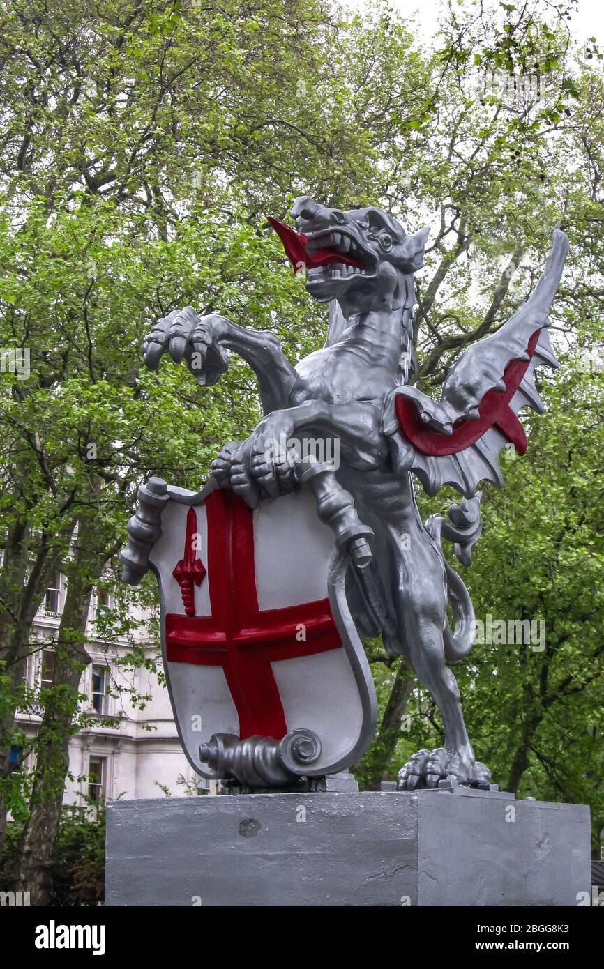 Statua in argento e rosso di un drago che tiene in mano gli inglesi Stemma situato vicino al fiume Tamigi Foto Stock