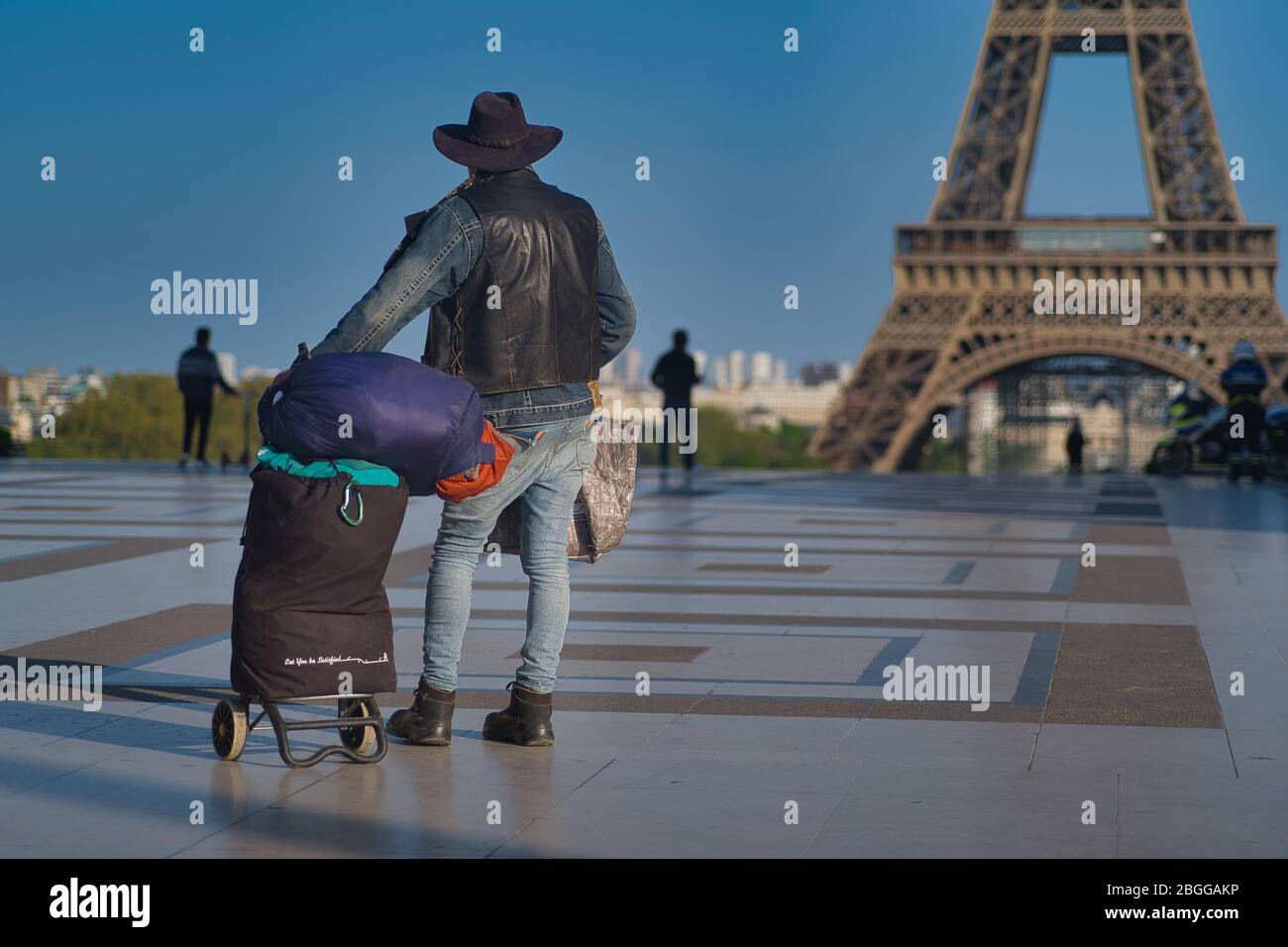 Un uomo solitario che guarda la Torre Eiffel a Parigi in Francia durante il blocco del Covid-19. E' una struttura incredibile e una meraviglia del mondo. Foto Stock