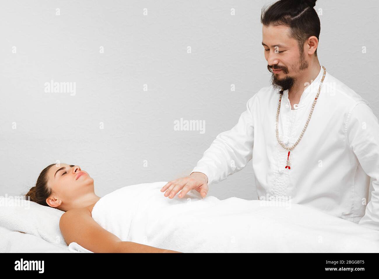 Medico di medicina orientale tradizionale che fa massaggio energetico non  contatto ad una donna bella in un salone termale. Il massaggio energetico  riprende la circolazione Foto stock - Alamy