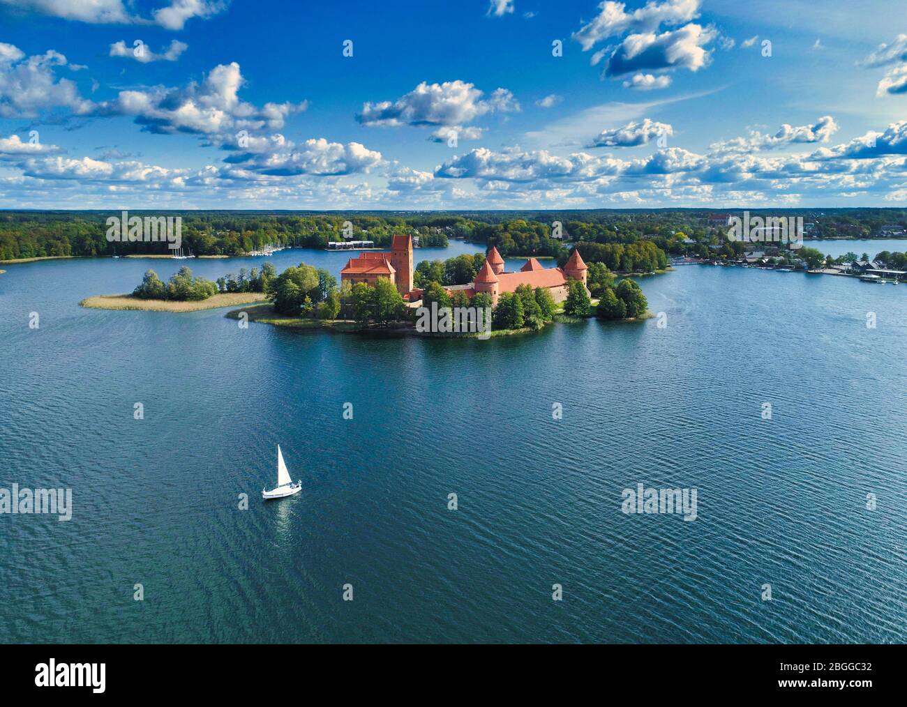 Barca a vela accanto al Castello dell'Isola di Trakai, Lituania Foto Stock