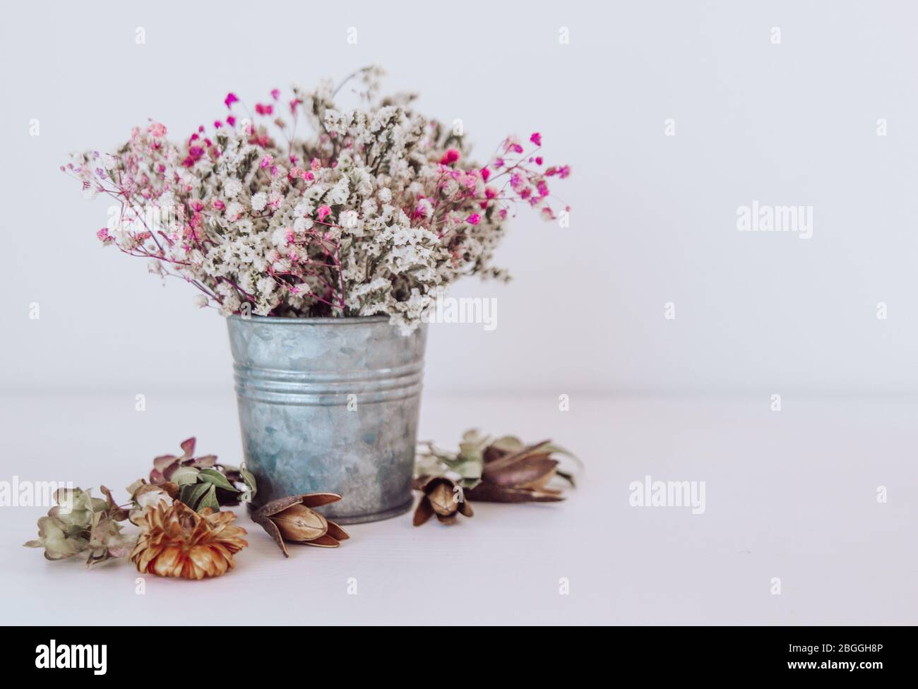 Fiori secchi in un secchio di ferro rustico. Composizione floreale stile boho. Foto Stock