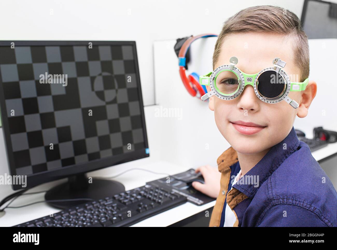 Ragazzo con occhiali speciali riceve il trattamento per i suoi occhi. Trattamento con ambliopia. Software-computer trattamento di acuità visiva Foto Stock