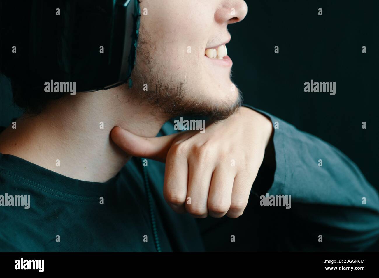 Il giocatore di MAD ha un aspetto violento, facendo segni minacciosi, gesturando con il dito indice al collo come se tagliasse la gola. Sorriso malvagio Foto Stock