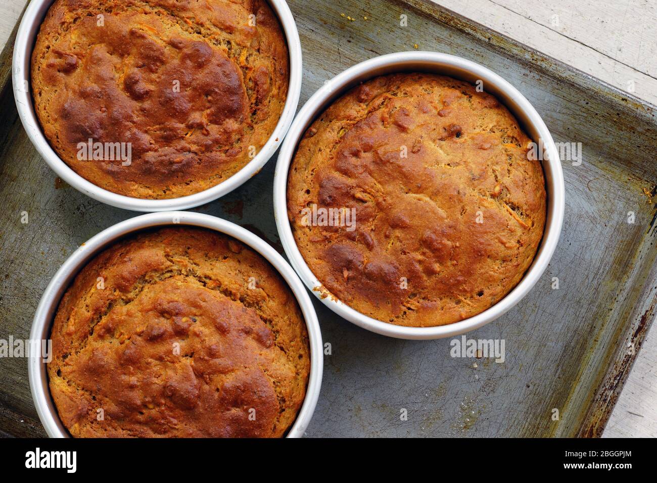 Tre torte appena cotte di carote vegane in uno stampo per torte Foto Stock