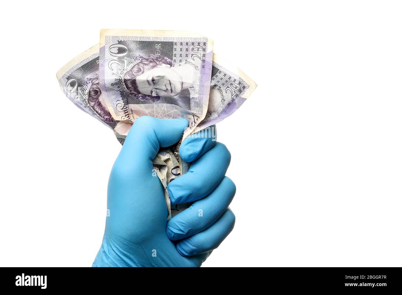 Covid 19 finanza concetto immagine di un uomo in un guanto chirurgico di gomma che tiene UK 20 banconote da libbra come coronavirus schiaccia l'economia Foto Stock