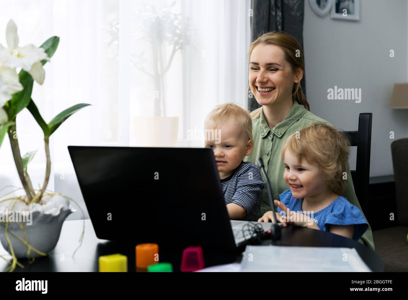 madre con i bambini che usano il computer portatile e si divertono insieme a casa Foto Stock