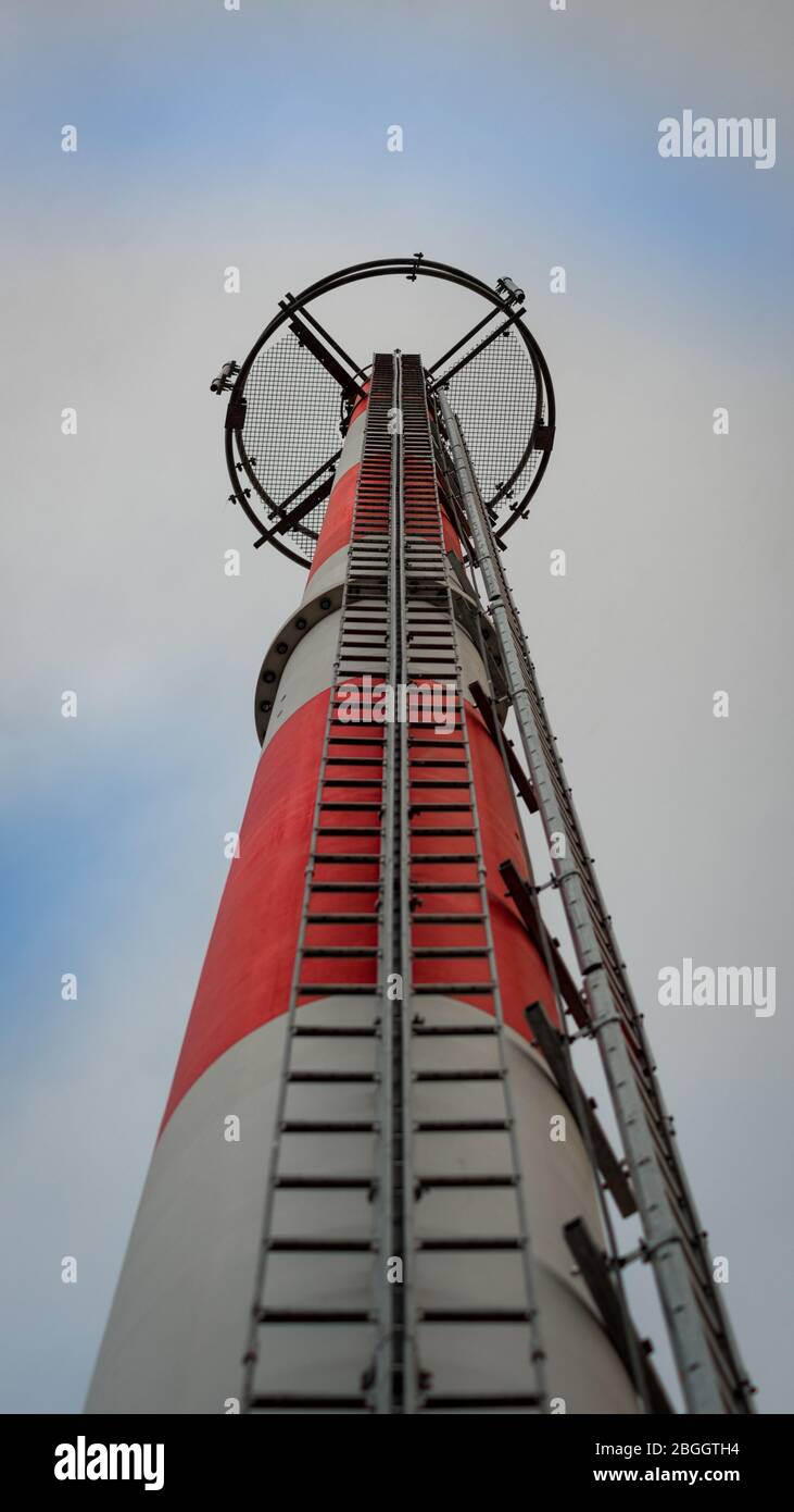 Torre di comunicazione GSM alta rossa e bianca con antenne sulla parte superiore; vista dal basso Foto Stock