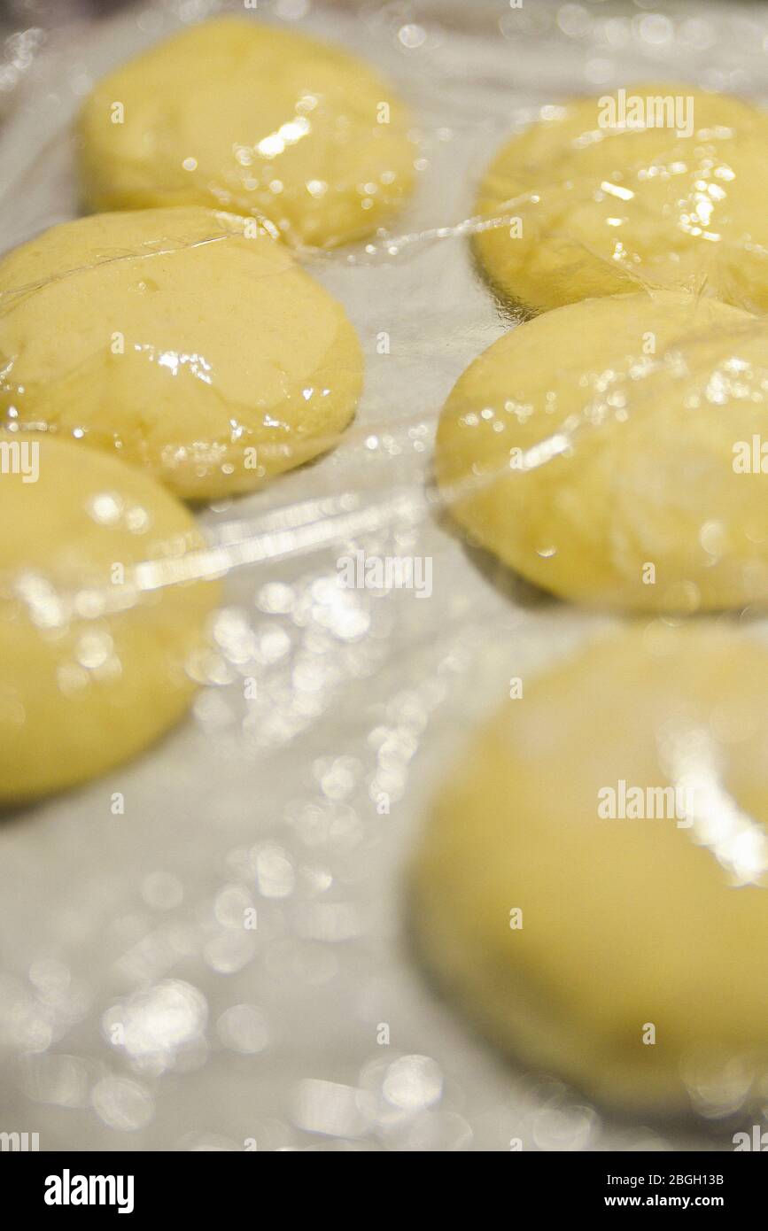 Pasta di pane su foglio di cottura sotto la pellicola trasparente Foto Stock