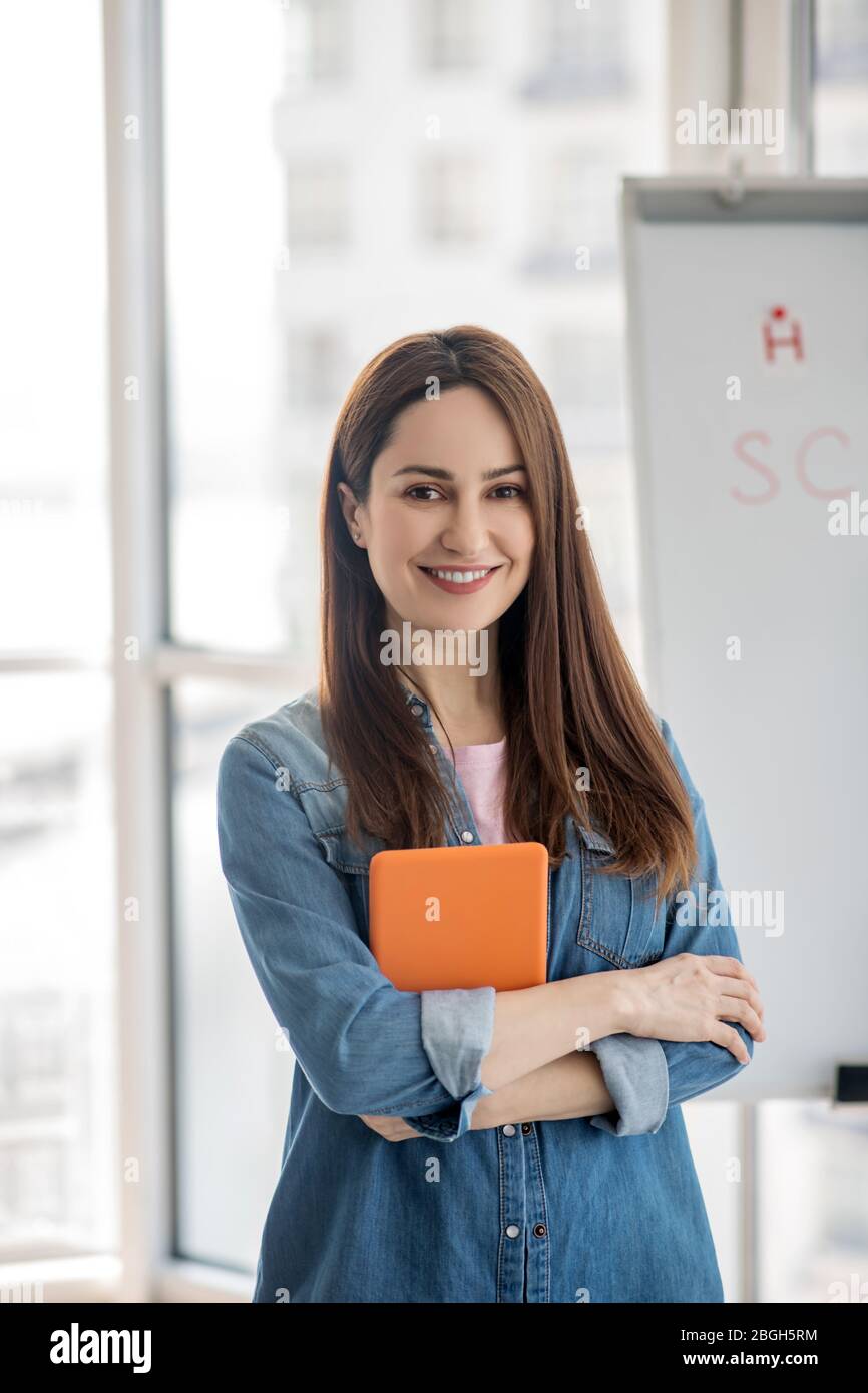 Giovane donna sorridente con un tablet in mano. Foto Stock