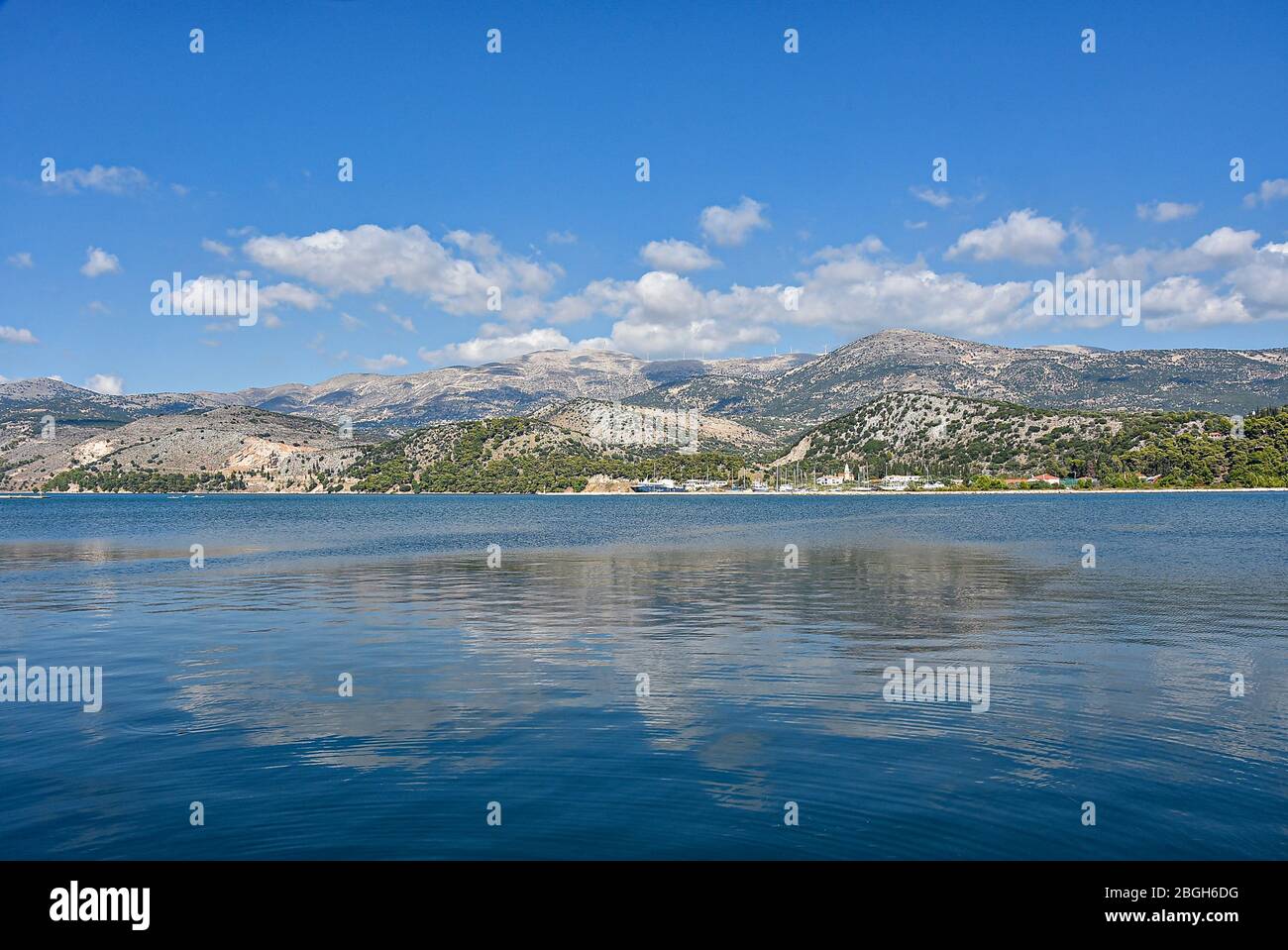 Una vista su una bella vista da Argostoli, con montagne sullo sfondo riflesse nel mare Foto Stock