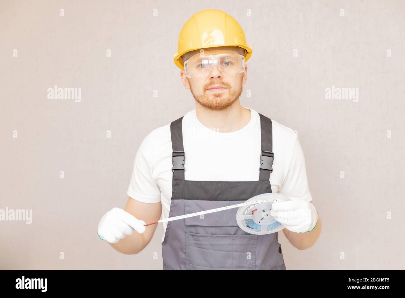 Elettricista che installa il nastro di montaggio striscia LED illuminazione decorativa Foto Stock