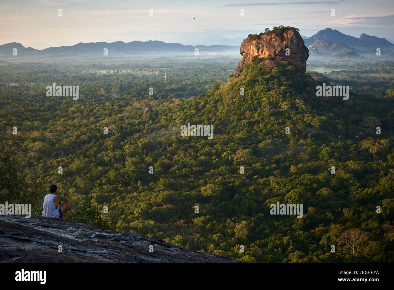 Un turista contempla l'alba a Sigiriya Rock, Sri Lanka, da Pidurangala Rock. Sigiriya Rock è una popolare attrazione turistica è un mondo UNESCO Foto Stock