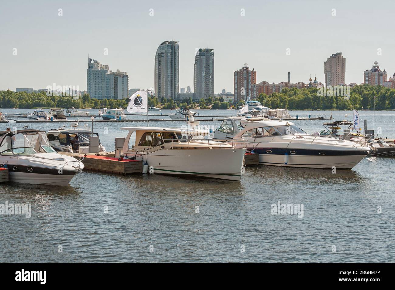 KIEV, UCRAINA - 05 GIUGNO 2015: Yacht moderni ormeggiati sul fiume Dnieper, quartiere residenziale di Obolon sullo sfondo, durante IBYS, International Bo Foto Stock