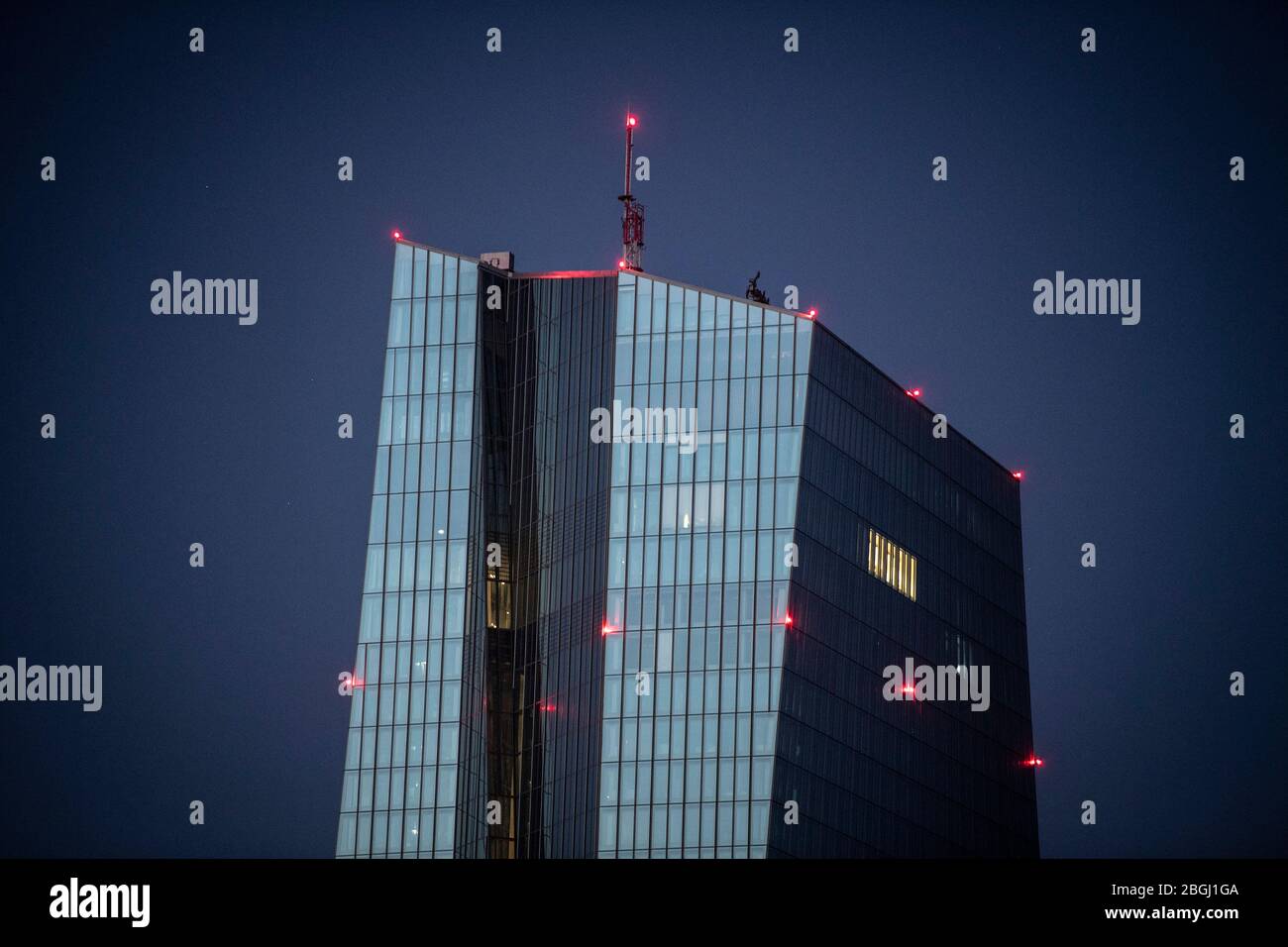 21 aprile 2020, Hessen, Francoforte sul meno: Solo poche luci brillano in tarda serata ai piani superiori della Banca centrale europea. Foto: Boris Roessler/dpa Foto Stock