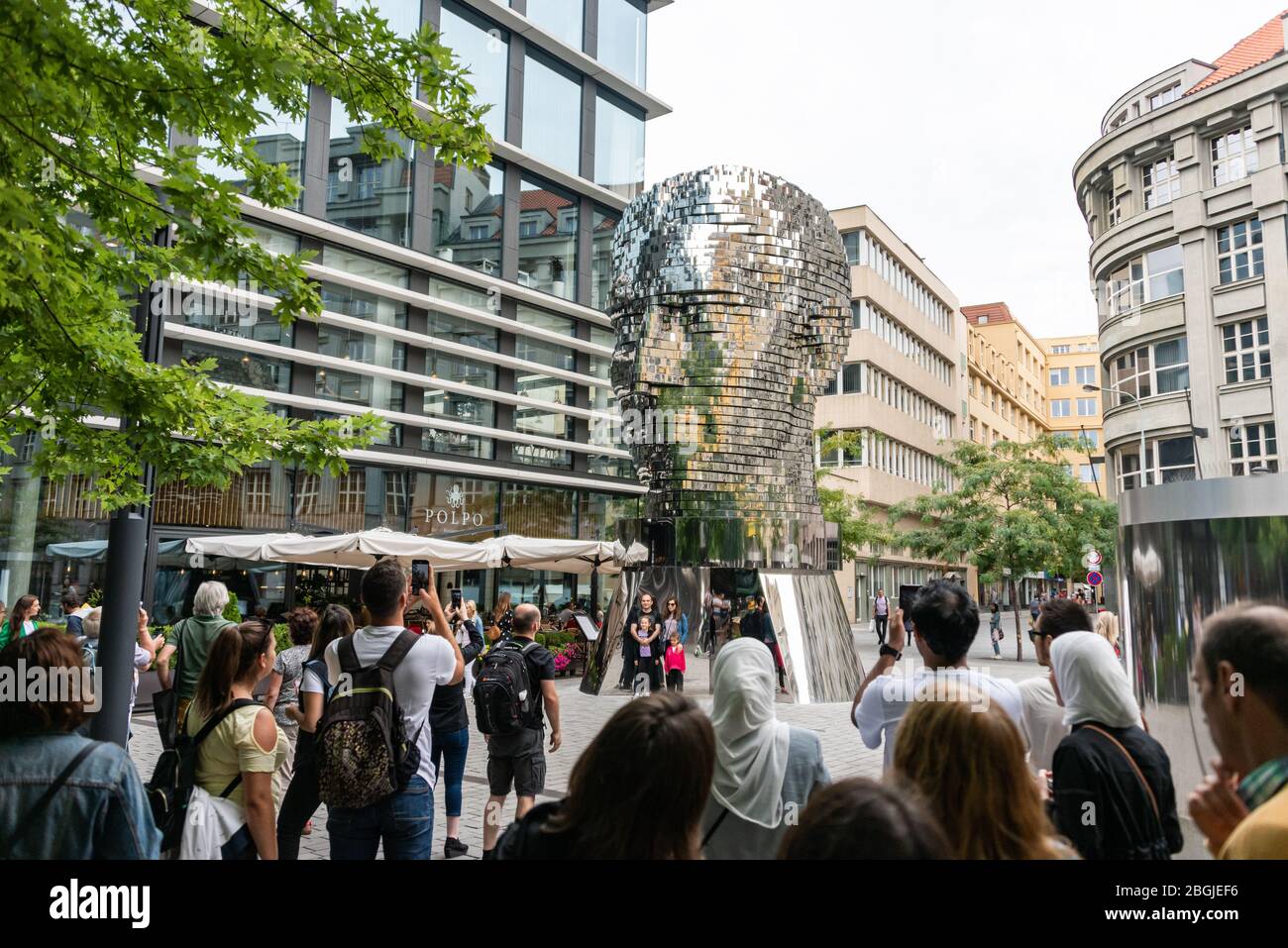 Persone, turisti che guardano la testa di Franz Kafka conosciuta come la statua di Kafka scultura all'aperto di David Cerny, installato fuori del Quadrio shopping Foto Stock
