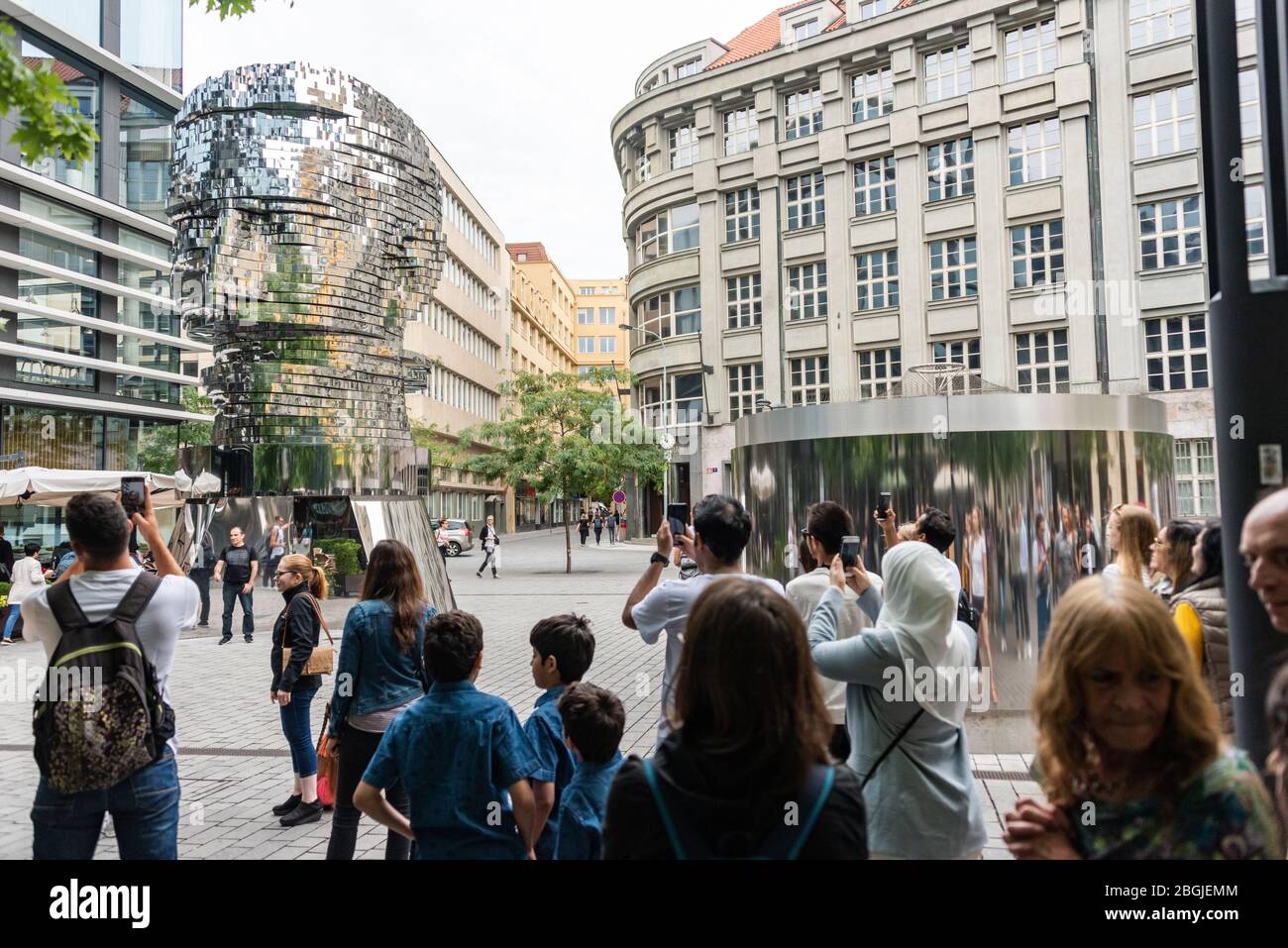 Persone, turisti che guardano la testa di Franz Kafka conosciuta come la statua di Kafka scultura all'aperto di David Cerny, installato fuori del Quadrio shopping Foto Stock