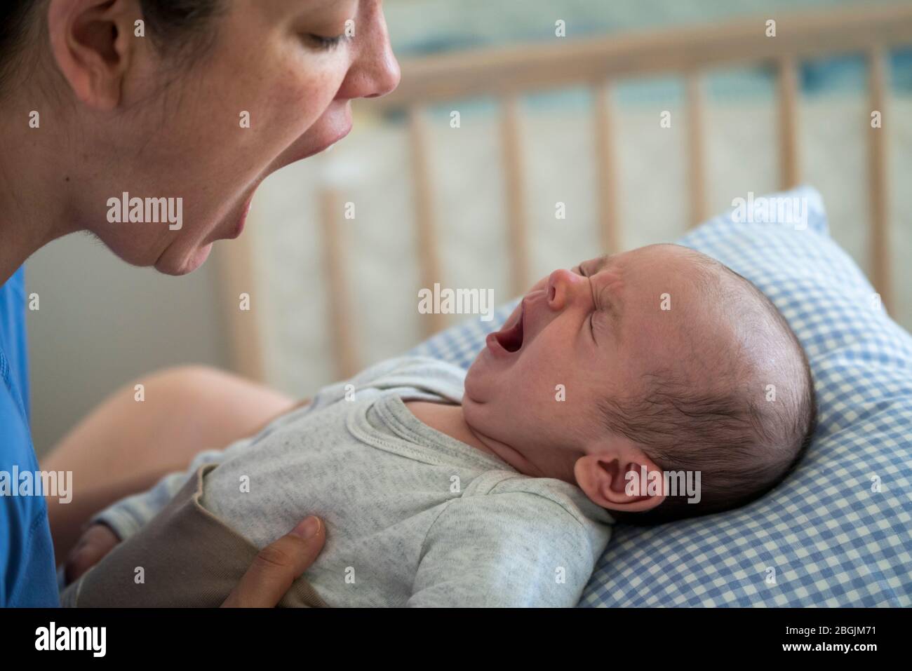 Madre con bocca aperta imitazione del bambino che sbava a casa Foto Stock