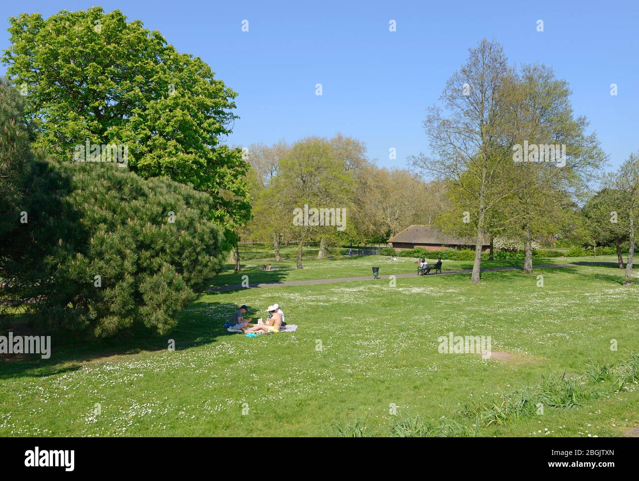 Un gruppo gode del tempo soleggiato nel parco pubblico Royal Victoria Gardens a nord di Woolwich, Londra, Regno Unito Foto Stock