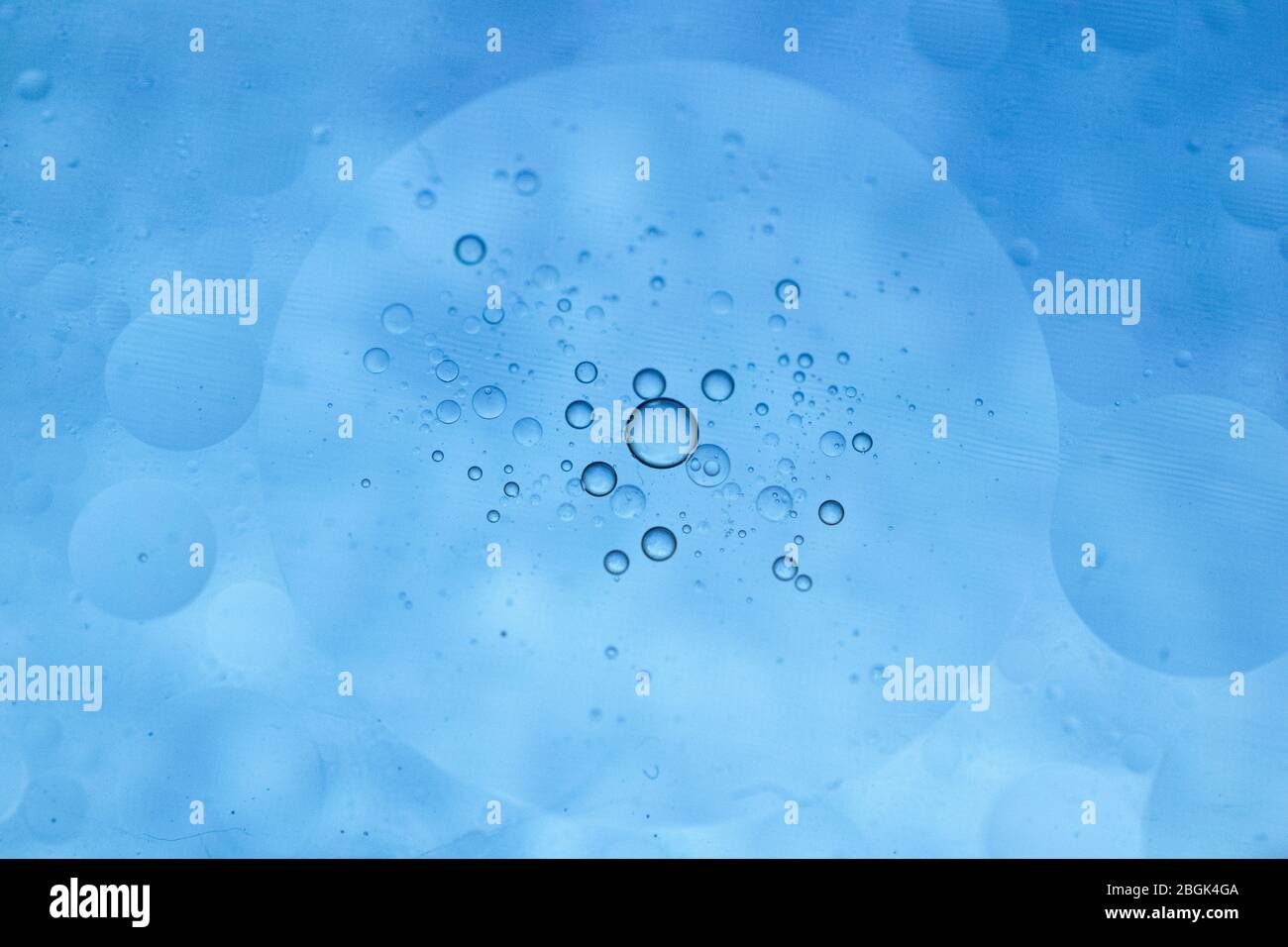 Cerchi blu brillante, olio e acqua Foto Stock