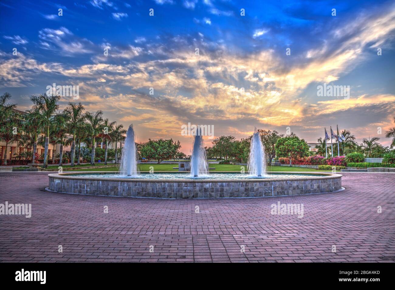 Tramonto su una fontana con tre spruzzi in una piscina riflettente a Napoli, Florida Foto Stock