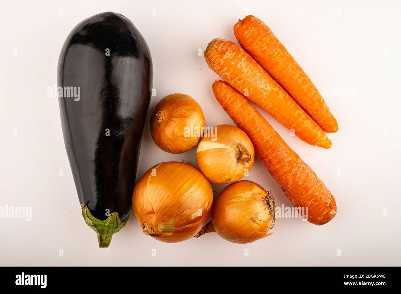 Cipolle succose, melanzane mature e carote d'arancia su sfondo bianco. Primo piano Foto Stock