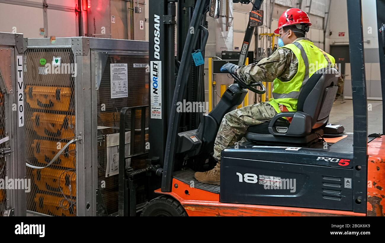 Soldato della Guardia Nazionale dell'Oregon. Adrian Muñoz Gonzalez, insieme al personale del Dipartimento per gli standard e la formazione sulla pubblica sicurezza (DPSST), carica 140 ventilatori Oregon su un camion per la spedizione a New York., 6 aprile 2020. (Foto della Guardia Nazionale dell'Oregon Army di Sgt. Prima Classe Zachary Holden, Oregon Military Department Public Affairs) Foto Stock