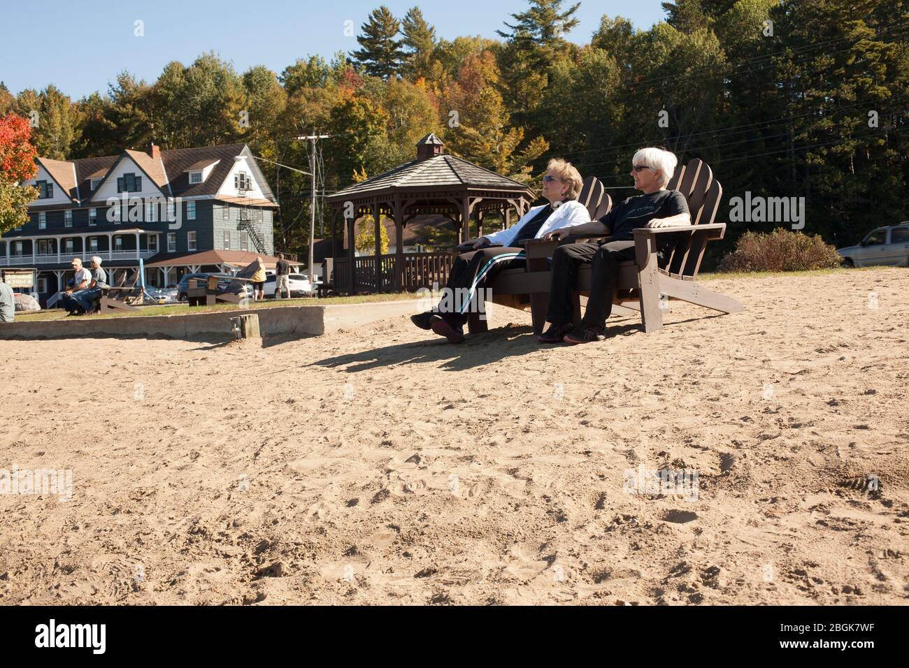 Due donne anziane si godono una giornata all'Upstate New York Long Lake, con l'Adirondack Hotel in background. Foto Stock