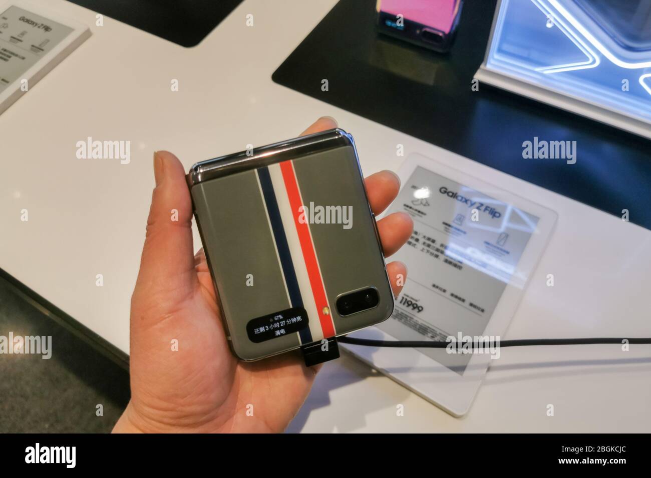 Un cliente possiede un modello di Samsung Galaxy Z Flip, uno smartphone pieghevole basato su Android che è esaurito il primo giorno, presso un'ammiraglia Samsung st Foto Stock