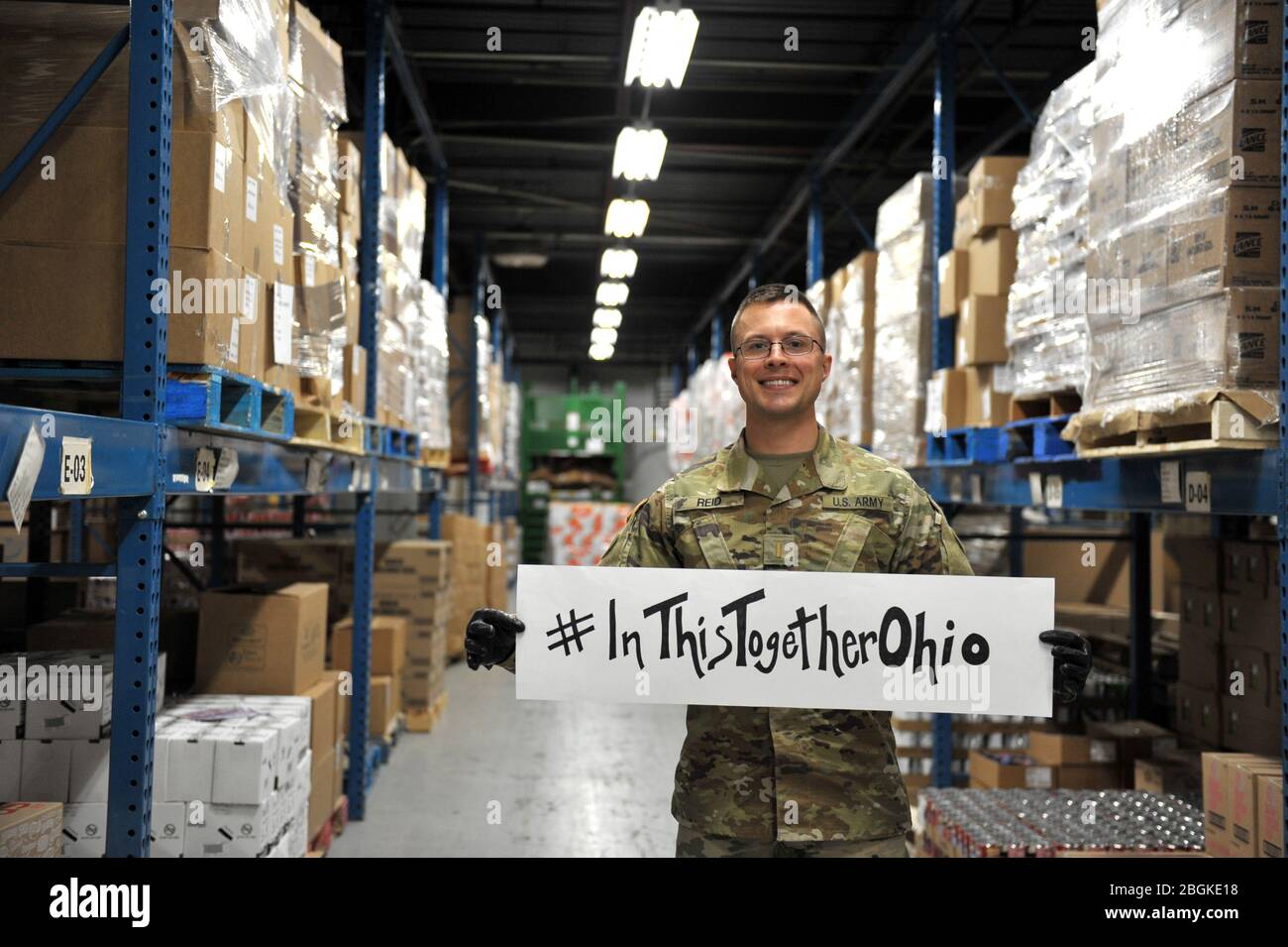 Stephen Reid, assegnato al Reggimento della Fanteria della Guardia Nazionale dell'Ohio, 37a squadra di combattimento della Brigata della Fanteria, condivide un messaggio di solidarietà mentre si trova presso la Toledo Northwestern Ohio Food Bank, 26 marzo 2020. Quasi 400 membri della Guardia Nazionale dell'Ohio sono stati attivati per fornire missioni umanitarie a sostegno degli sforzi di soccorso del COVID-19, continuando la lunga storia della Guardia Nazionale dell'Ohio di sostenere gli sforzi umanitari in tutto l'Ohio e la nazione. Foto della Guardia Nazionale aerea di Senior Master Sgt. Beth Holliker. Foto Stock