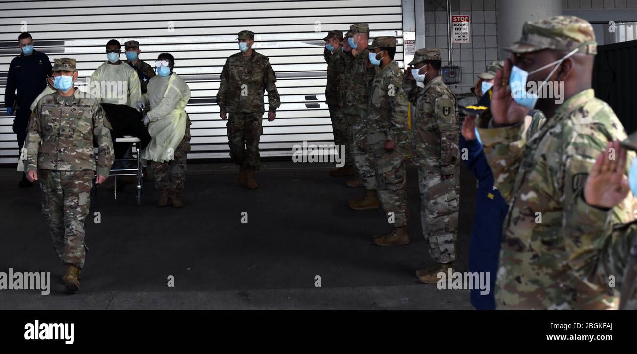 Il cappellano dell'esercito (maggiore) Ivan Arreguin guida la processione come personale militare e civile che lavora alla stazione medica di Javits New York, eretta al Jacob Javits Convention Center a New York City, Formare un cordone per rendere onore militare ad un veterano morto di COVID19 mentre un paziente alla stazione medica il 19 aprile 2020. I membri dell'esercito attivo e della Guardia Nazionale di New York militari e civili con membri di servizio precedenti dell'esercito hanno preso parte al riconoscimento.(foto della Guardia Nazionale dell'aria degli Stati Uniti dal maggiore Patrick Cordova) Foto Stock