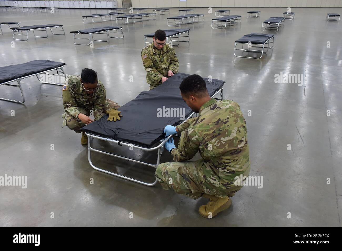 Soldati con la Guardia Nazionale dell'Esercito del Maryland assemblare una culla come parte della creazione di una Stazione Medica Federale nel Centro Congressi di Baltimora, a Baltimora, Maryland, Sabato, 28 Marzo 2020. Progettata per essere utilizzata come centro medico alternativo, la stazione è stata creata per alleviare il possibile sovraffollamento negli ospedali della zona a causa dell'epidemia di COVID-19. Circa 100 soldati hanno assistito con la messa a disposizione di 250 posti letto e attrezzature correlate nel centro congressi, mentre a livello nazionale quasi 14.000 membri della Guardia Nazionale sono in servizio fornendo forniture, la gestione di centri di test mobili e di lavoro Foto Stock