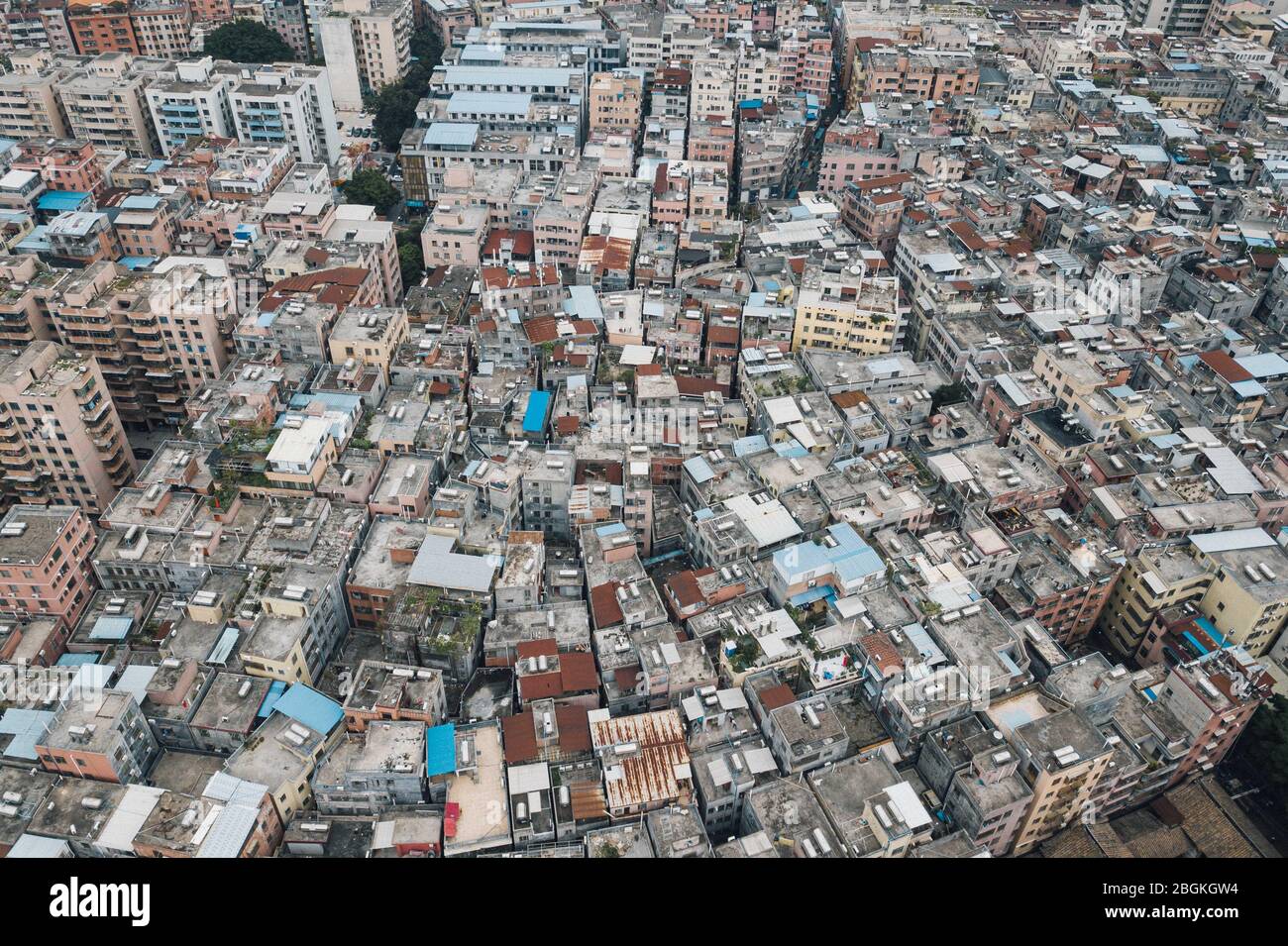 Una vista aerea di file di edifici residenti di varie altezze erigendo al centro della città, formando un mondo incompatibile con i cieli moderni circostanti Foto Stock