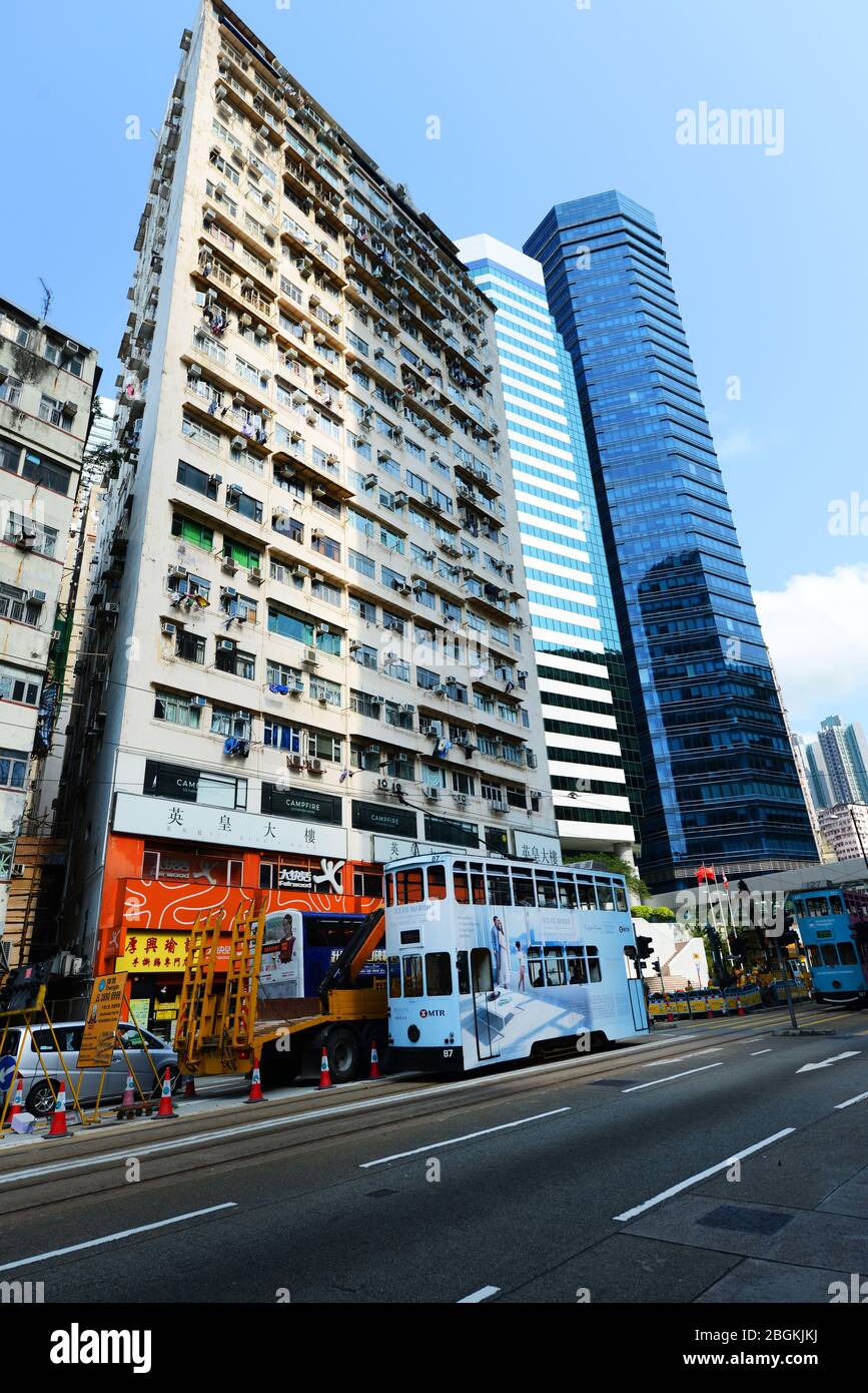 Vecchio edificio residenziale lungo i moderni grattacieli nella baia di HongKong. Foto Stock