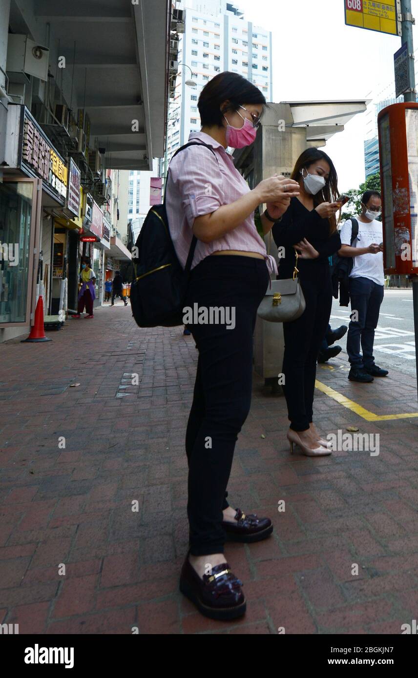 Hongkongers che indossano maschere chirurgiche durante la pandemia di Covid-19. Foto Stock