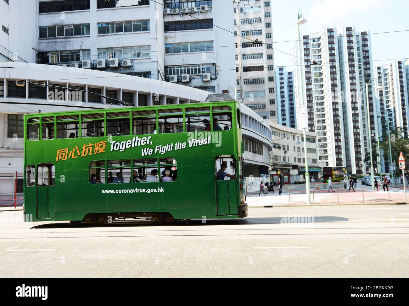 Un tram coperto con motivazione Coronavirus aggiungere su di esso a Hong Kong. Foto Stock