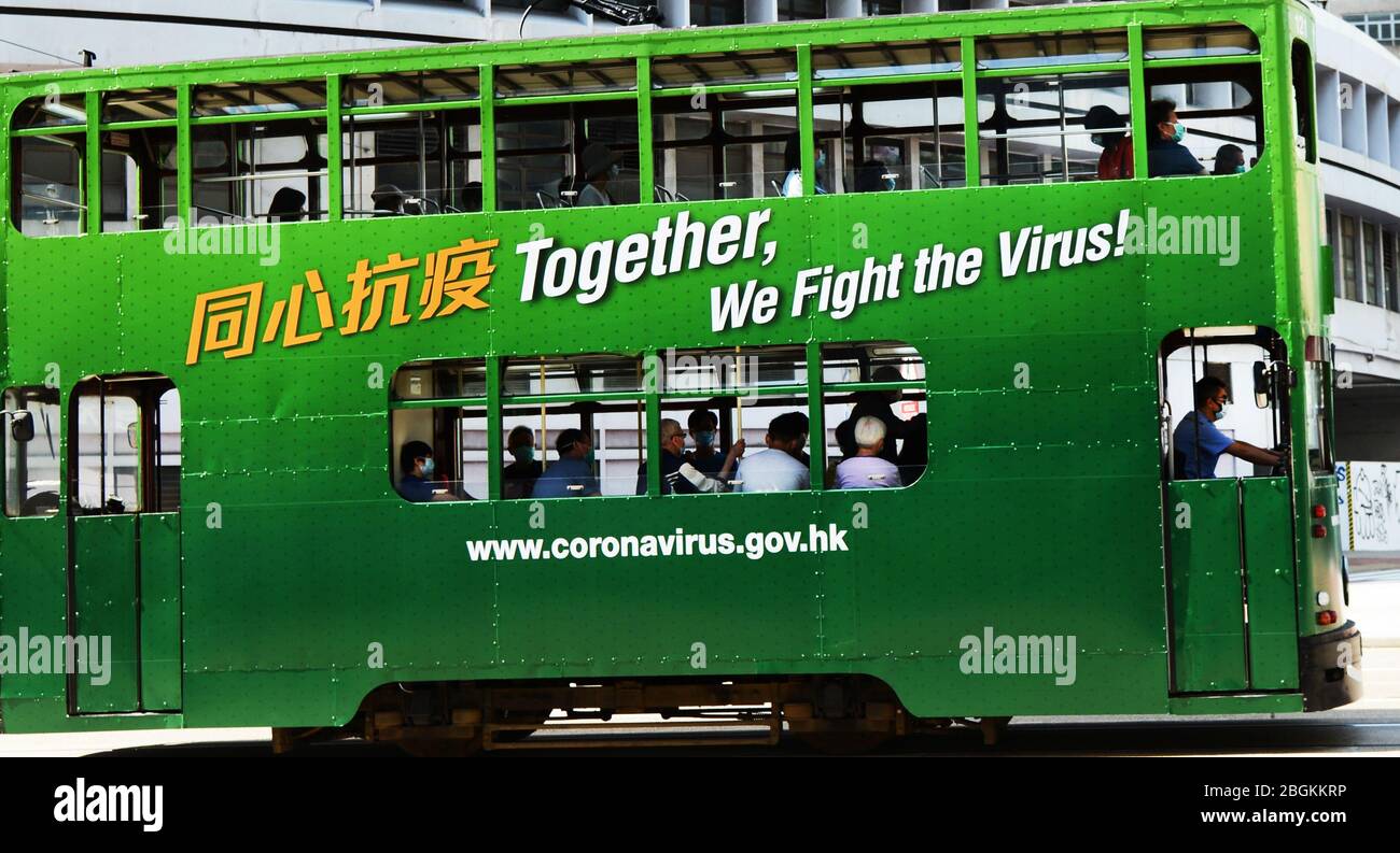 Un tram coperto con motivazione Coronavirus aggiungere su di esso a Hong Kong. Foto Stock
