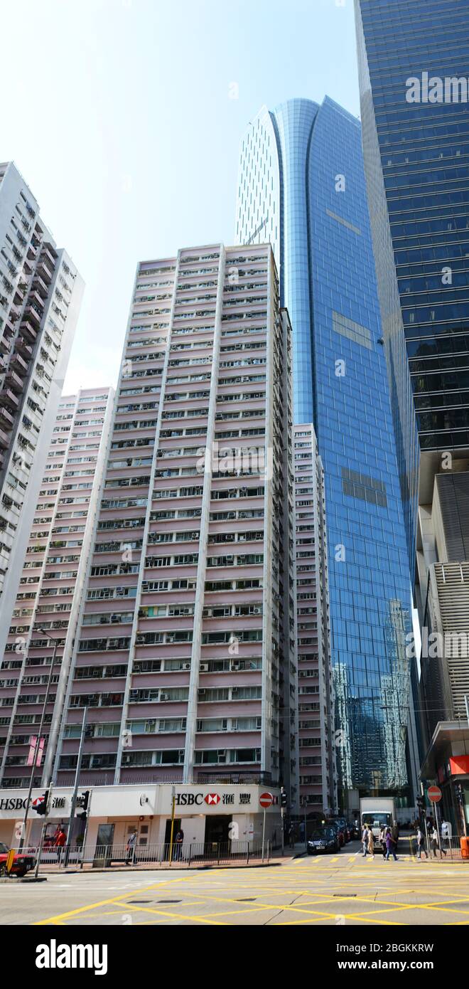 Vecchio edificio residenziale lungo i moderni grattacieli nella baia di HongKong. Foto Stock
